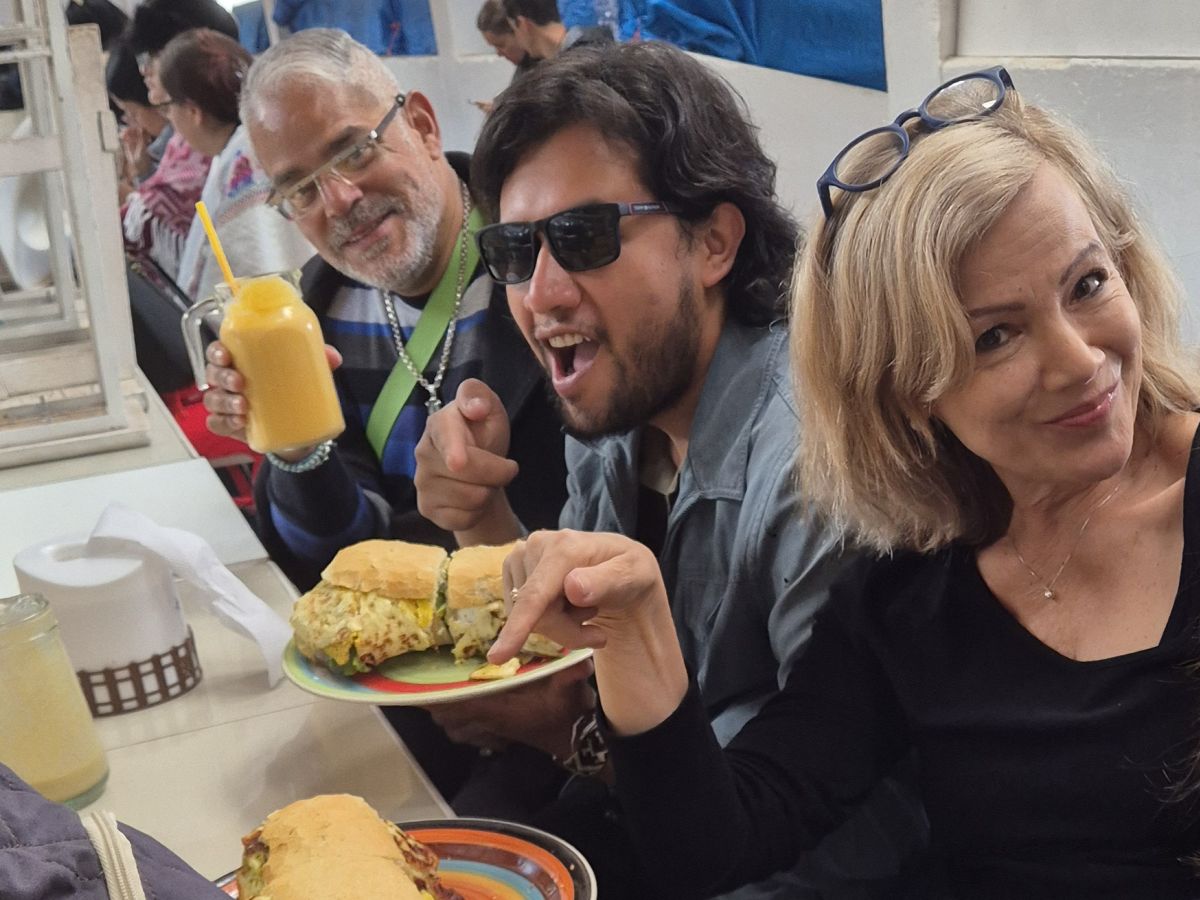 Three Anders Languages guests enjoying sandwiches and fruit drinks in Cusco